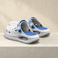 Arch support clog in white and blue on a stone ledge