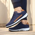 Navy casual sneaker with tan side stripe, worn